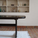 Table à manger Skovby en teck foncé avec plateau noir, piétement traîneau et deux rallonges, design danois des années 70.