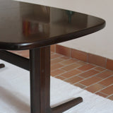 Table à manger Skovby en teck foncé avec plateau noir, piétement traîneau et deux rallonges, design danois des années 70.