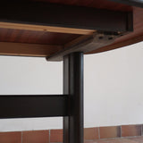 Table à manger Skovby en teck foncé avec plateau noir, piétement traîneau et deux rallonges, design danois des années 70.