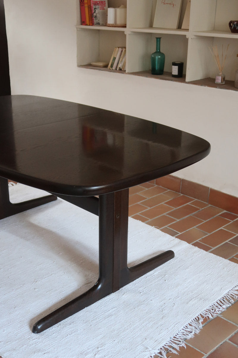Table à manger Skovby en teck foncé avec plateau noir, piétement traîneau et deux rallonges, design danois des années 70.