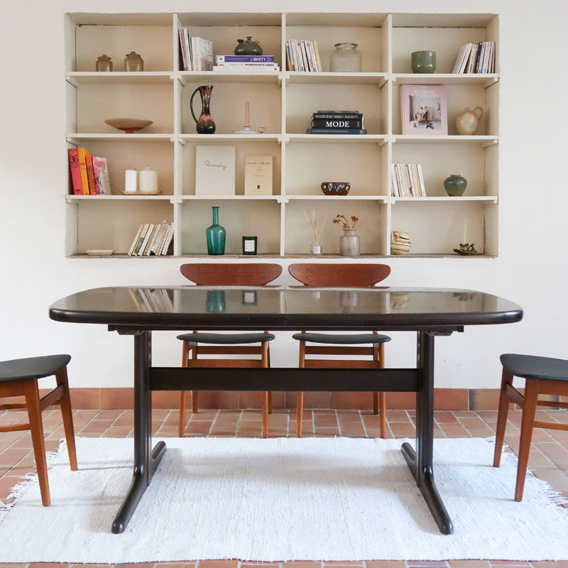 Table à manger Skovby en teck foncé avec plateau noir, piétement traîneau et deux rallonges, design danois des années 70.
