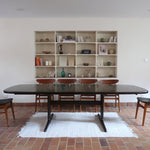 Table à manger Skovby en teck foncé avec plateau noir, piétement traîneau et deux rallonges, design danois des années 70.