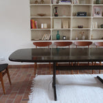 Table à manger Skovby en teck foncé avec plateau noir, piétement traîneau et deux rallonges, design danois des années 70.