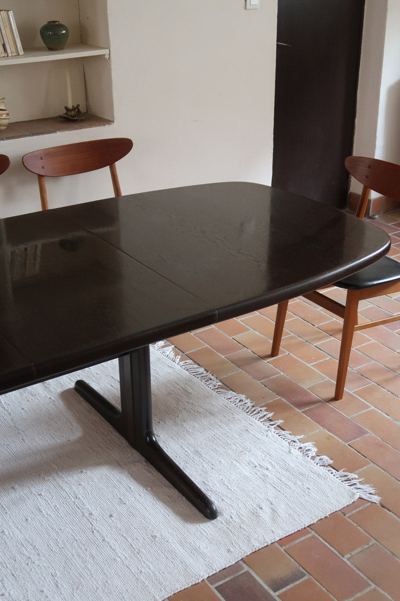 Table à manger Skovby en teck foncé avec plateau noir, piétement traîneau et deux rallonges, design danois des années 70.
