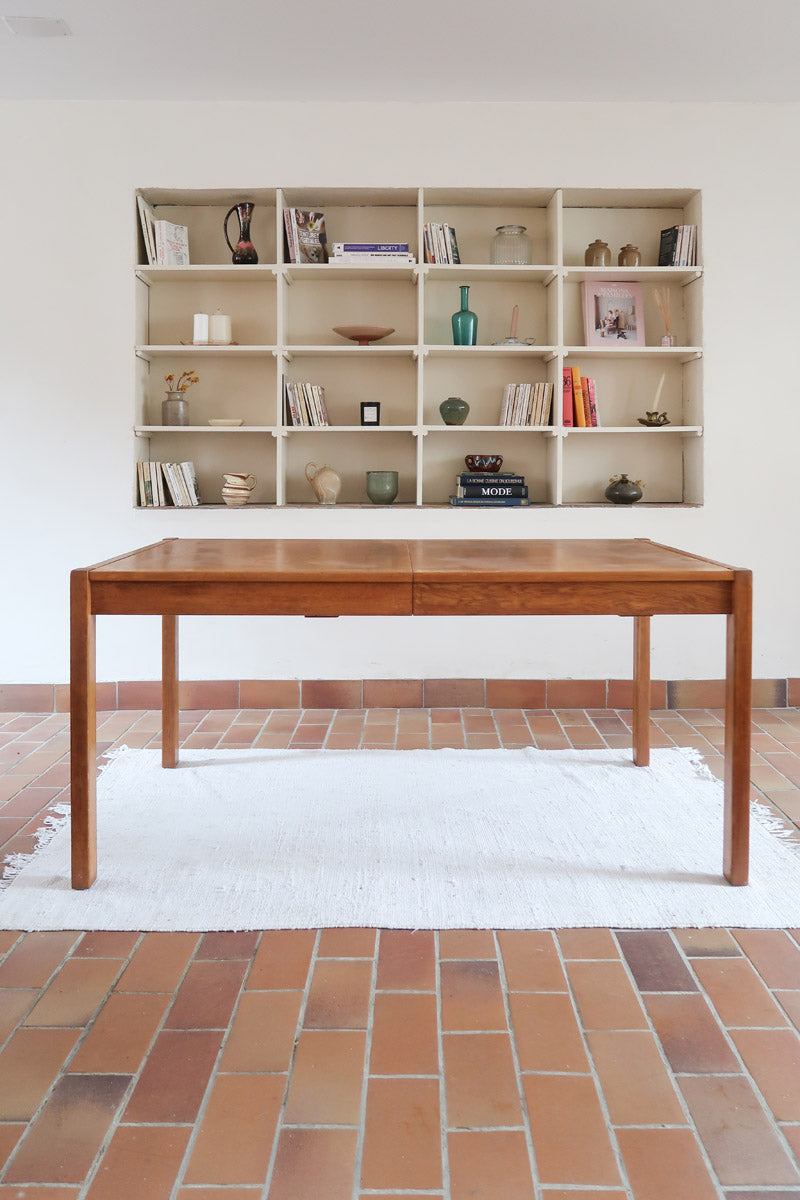 Table à manger extensible en bois massif années 60 avec deux rallonges intégrées sous le plateau.
