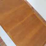 Table à manger extensible en bois massif années 60 avec deux rallonges intégrées sous le plateau.