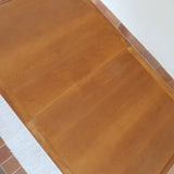 Table à manger extensible en bois massif années 60 avec deux rallonges intégrées sous le plateau.