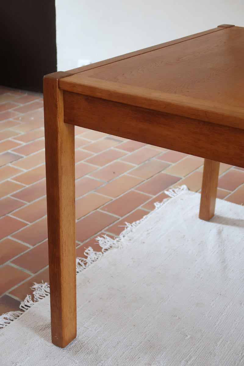 Table à manger extensible en bois massif années 60 avec deux rallonges intégrées sous le plateau.