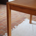 Table à manger extensible en bois massif années 60 avec deux rallonges intégrées sous le plateau.