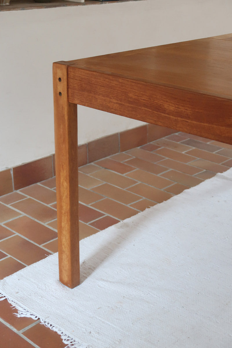 Table à manger extensible en bois massif années 60 avec deux rallonges intégrées sous le plateau.