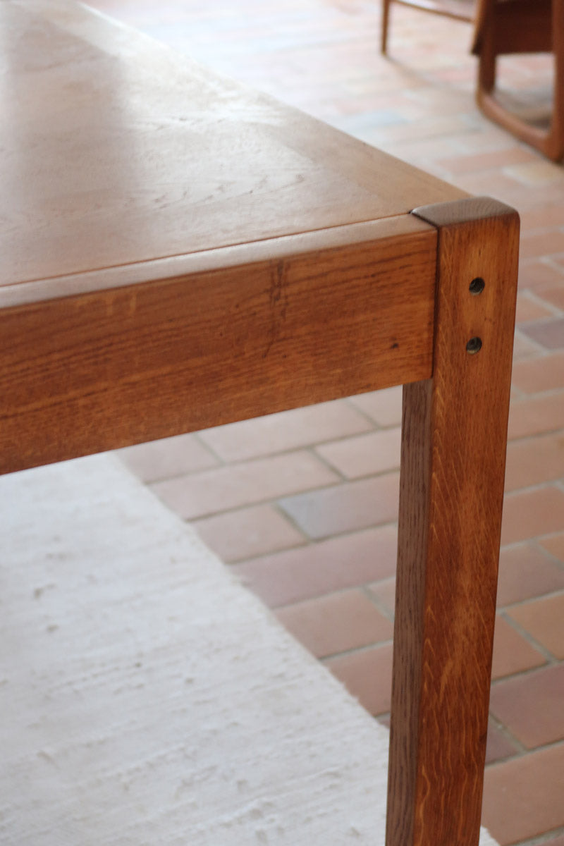 Table à manger extensible en bois massif années 60 avec deux rallonges intégrées sous le plateau.