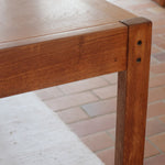 Table à manger extensible en bois massif années 60 avec deux rallonges intégrées sous le plateau.