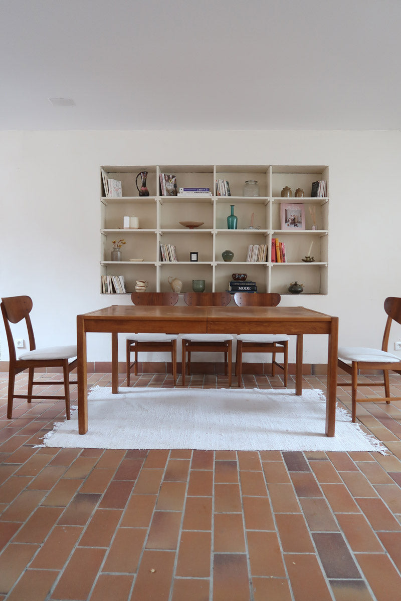 Table à manger extensible en bois massif années 60 avec deux rallonges intégrées sous le plateau.