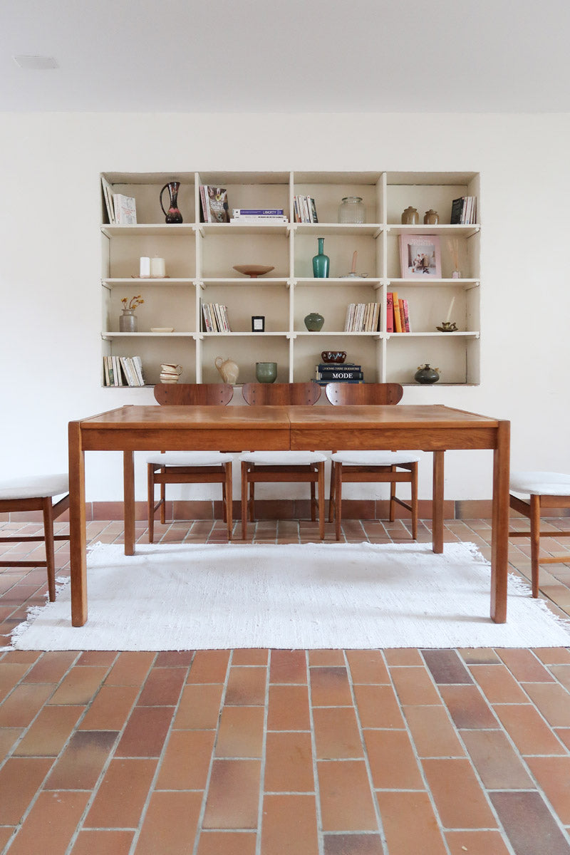Table à manger extensible en bois massif années 60 avec deux rallonges intégrées sous le plateau.
