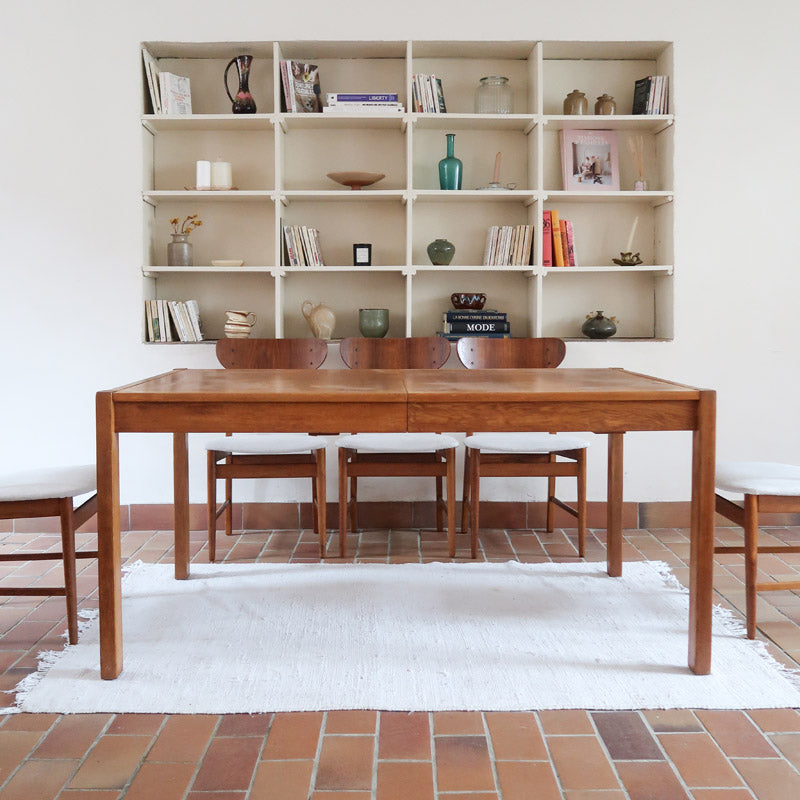 Table à manger extensible en bois massif années 60 avec deux rallonges intégrées sous le plateau.
