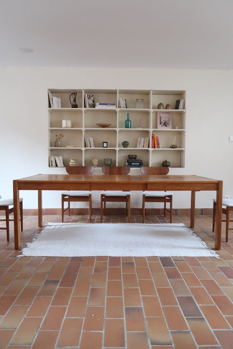 Table à manger extensible en bois massif années 60 avec deux rallonges intégrées sous le plateau.