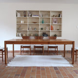 Table à manger extensible en bois massif années 60 avec deux rallonges intégrées sous le plateau.