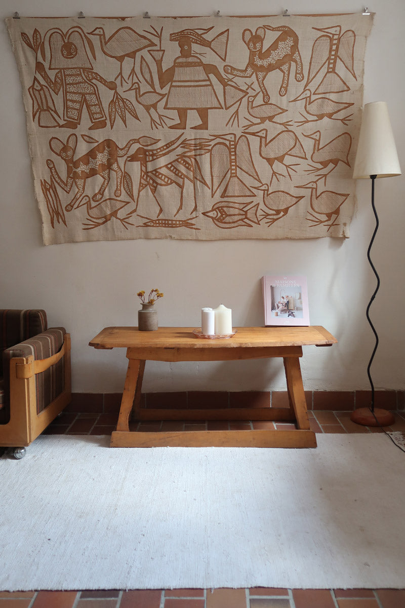 Table basse en bois massif rustique avec plateau épais et piètement trapézoïdal, style brutaliste années 50.