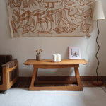 Table basse en bois massif rustique avec plateau épais et piètement trapézoïdal, style brutaliste années 50.
