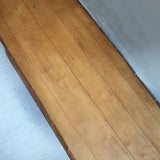 Table basse en bois massif rustique avec plateau épais et piètement trapézoïdal, style brutaliste années 50.