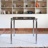 Table vintage en chrome tubulaire avec plateau carré en verre fumé, style années 70.