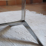 Table basse design années 70 avec plateau noir rectangulaire et piétement en acier brossé en forme de patins.
