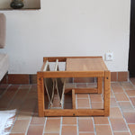 Table basse vintage en pin massif années 70, structure cubique chevillée, porte-revues en toile écrue suspendu sous le plateau, esprit Maison Regain
