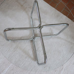 Table basse ronde des années 70 avec plateau en verre et base en tubes chromés en croix.