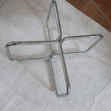 Table basse ronde des années 70 avec plateau en verre et base en tubes chromés en croix.