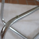 Table basse ronde des années 70 avec plateau en verre et base en tubes chromés en croix.