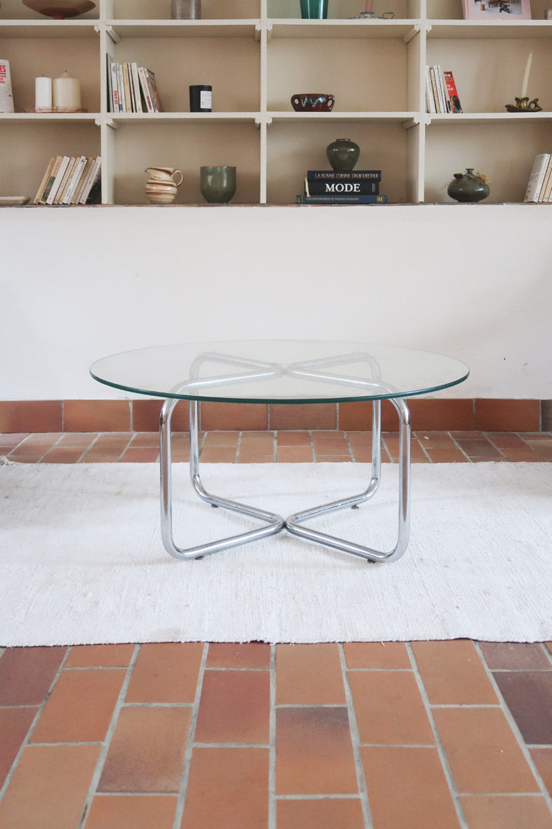 Table basse ronde des années 70 avec plateau en verre et base en tubes chromés en croix.