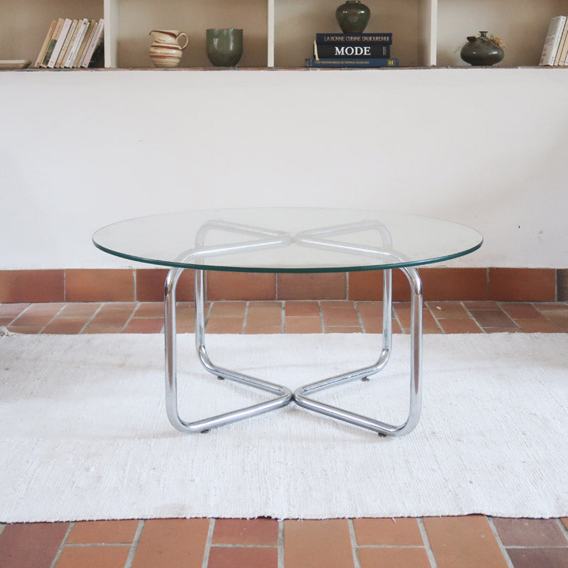 Table basse ronde des années 70 avec plateau en verre et base en tubes chromés en croix.