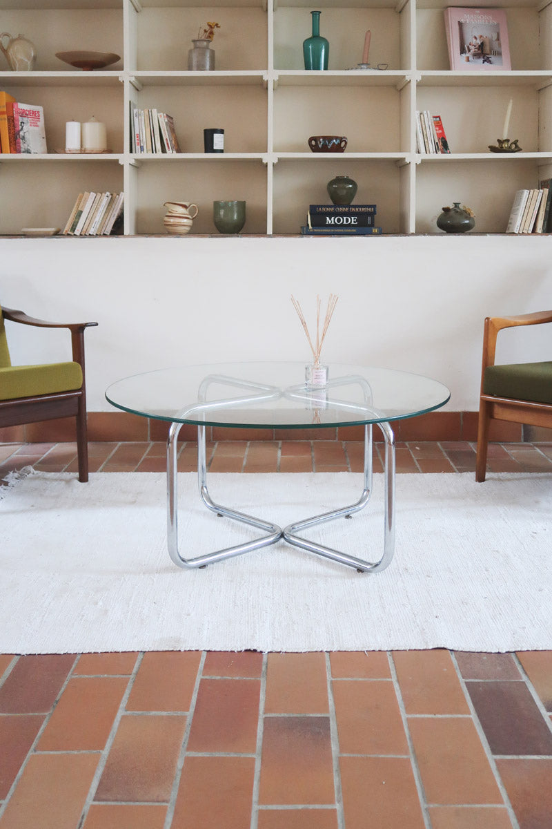 Table basse ronde des années 70 avec plateau en verre et base en tubes chromés en croix.