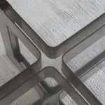 Table basse vintage en verre fumé, années 70, grand plateau rectangulaire à angles arrondis, piétement en inox brossé composé de deux cadres en U réunis par une croix centrale