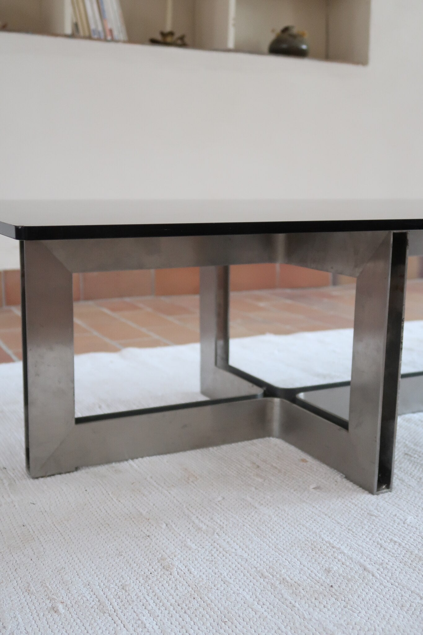 Table basse vintage en verre fumé, années 70, grand plateau rectangulaire à angles arrondis, piétement en inox brossé composé de deux cadres en U réunis par une croix centrale