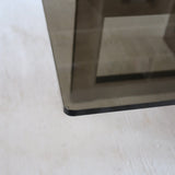 Table basse vintage en verre fumé, années 70, grand plateau rectangulaire à angles arrondis, piétement en inox brossé composé de deux cadres en U réunis par une croix centrale