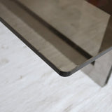 Table basse vintage en verre fumé, années 70, grand plateau rectangulaire à angles arrondis, piétement en inox brossé composé de deux cadres en U réunis par une croix centrale