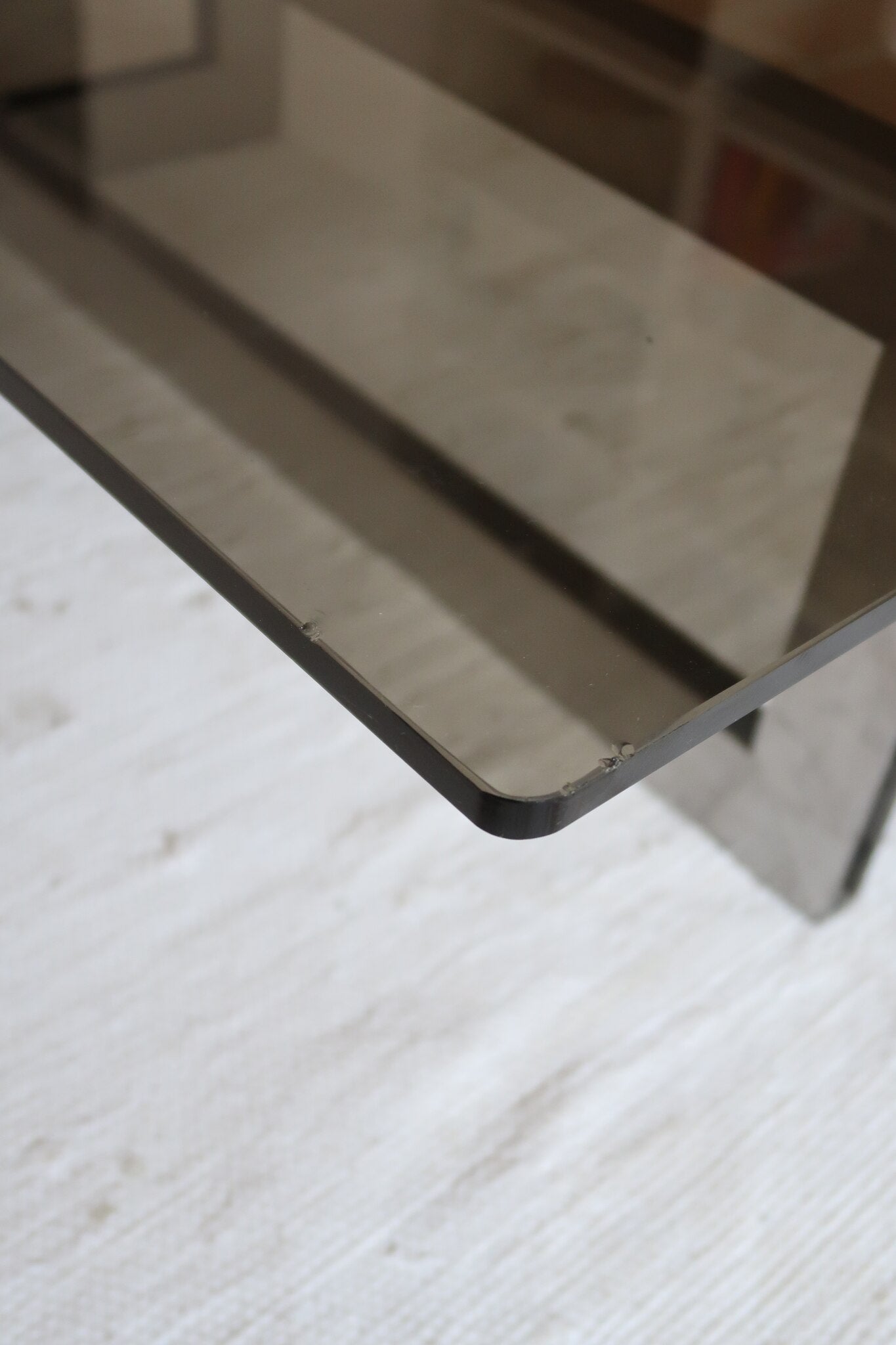 Table basse vintage en verre fumé, années 70, grand plateau rectangulaire à angles arrondis, piétement en inox brossé composé de deux cadres en U réunis par une croix centrale