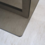 Table basse vintage en verre fumé, années 70, grand plateau rectangulaire à angles arrondis, piétement en inox brossé composé de deux cadres en U réunis par une croix centrale