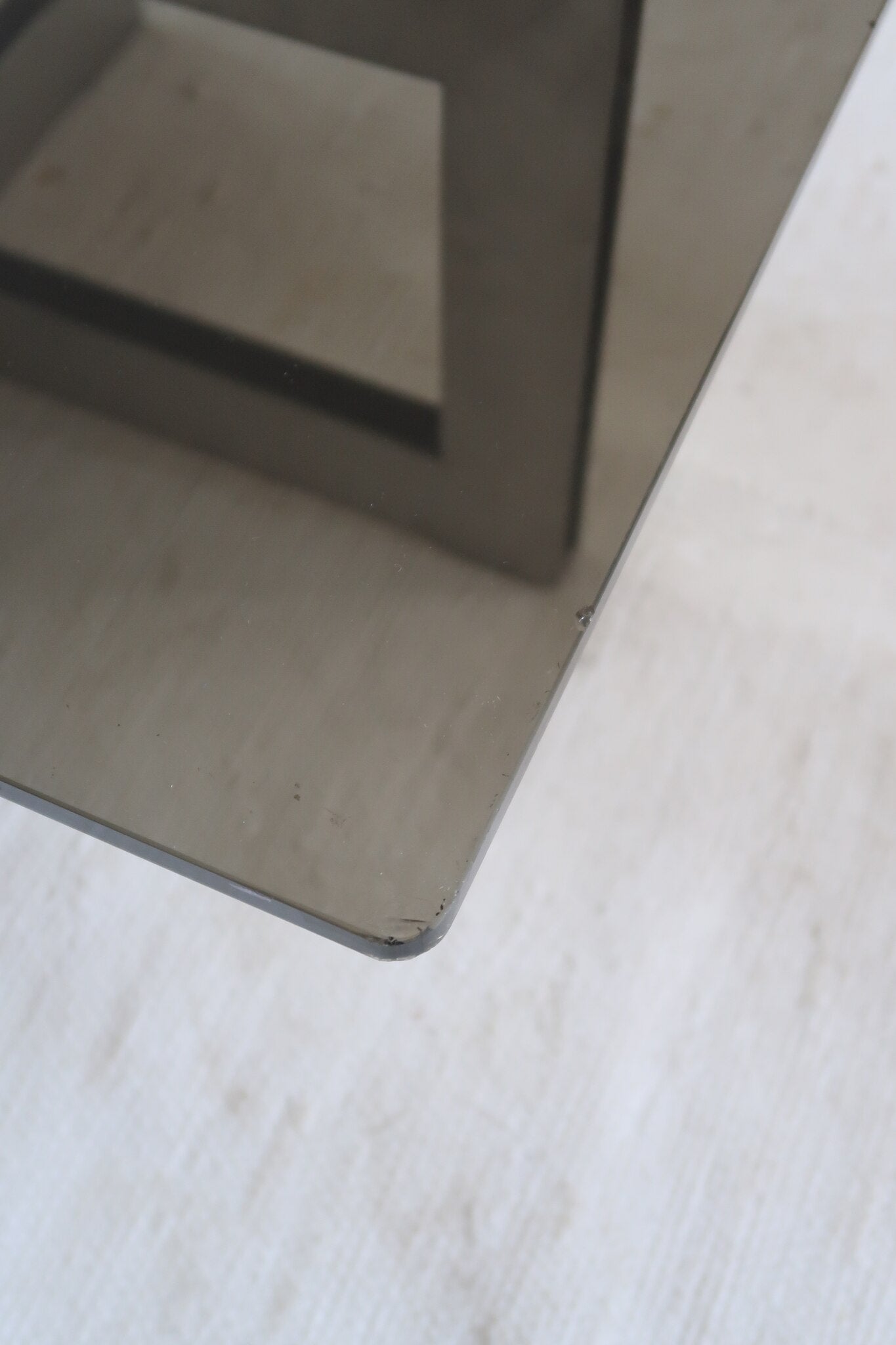 Table basse vintage en verre fumé, années 70, grand plateau rectangulaire à angles arrondis, piétement en inox brossé composé de deux cadres en U réunis par une croix centrale