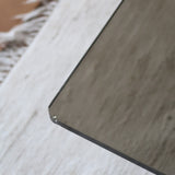 Table basse vintage en verre fumé, années 70, grand plateau rectangulaire à angles arrondis, piétement en inox brossé composé de deux cadres en U réunis par une croix centrale