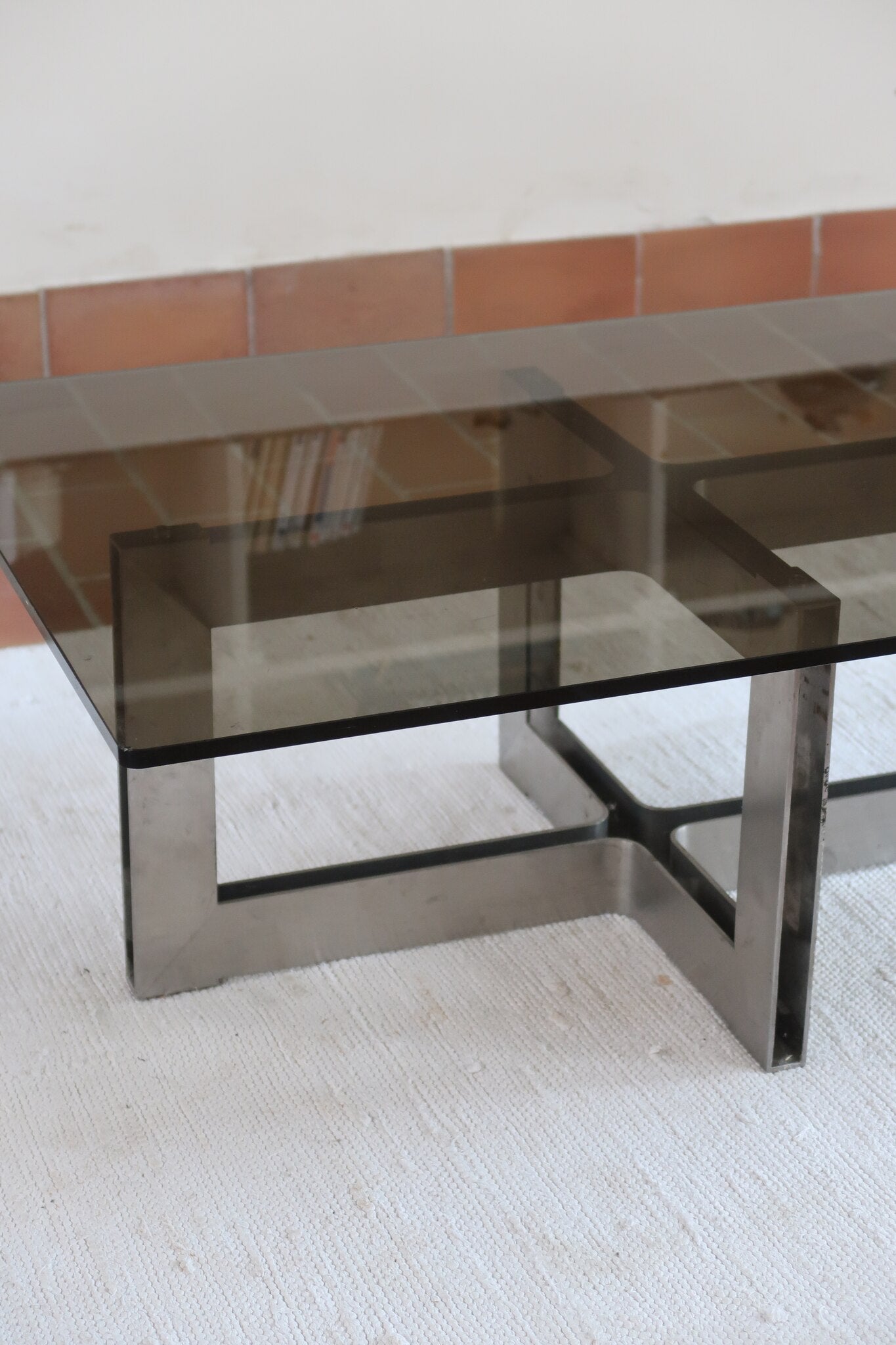 Table basse vintage en verre fumé, années 70, grand plateau rectangulaire à angles arrondis, piétement en inox brossé composé de deux cadres en U réunis par une croix centrale