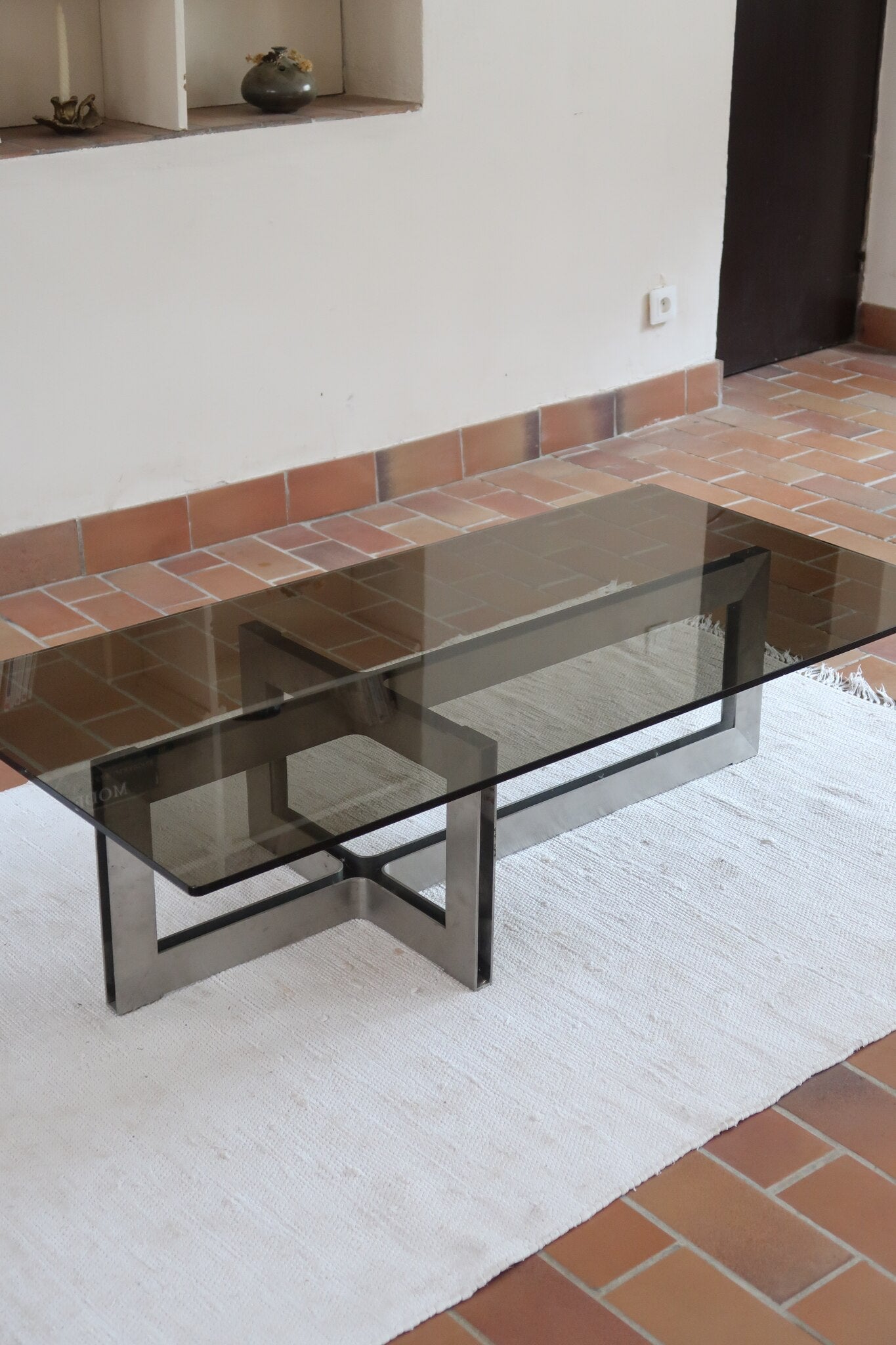 Table basse vintage en verre fumé, années 70, grand plateau rectangulaire à angles arrondis, piétement en inox brossé composé de deux cadres en U réunis par une croix centrale