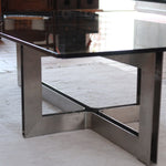 Table basse vintage en verre fumé, années 70, grand plateau rectangulaire à angles arrondis, piétement en inox brossé composé de deux cadres en U réunis par une croix centrale
