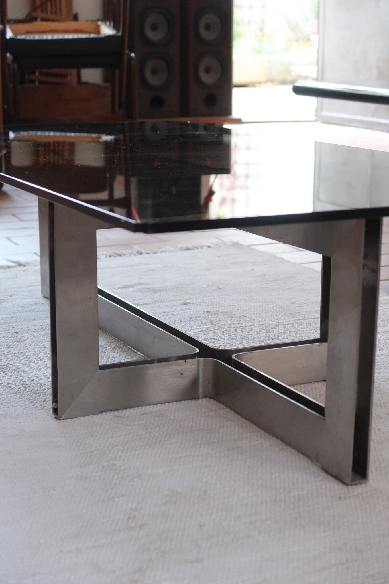 Table basse vintage en verre fumé, années 70, grand plateau rectangulaire à angles arrondis, piétement en inox brossé composé de deux cadres en U réunis par une croix centrale