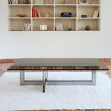 Table basse vintage en verre fumé, années 70, grand plateau rectangulaire à angles arrondis, piétement en inox brossé composé de deux cadres en U réunis par une croix centrale