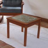 Table basse vintage en teck des années 60 avec plateau carré en céramique à motif.