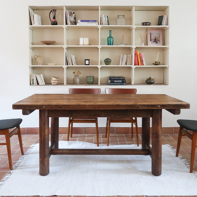 Table brutaliste 8 personnes George Robert en bois massif teinté foncé France années 70, plateau à nœuds apparents, 4 pieds cylindriques massifs, entretoise en H