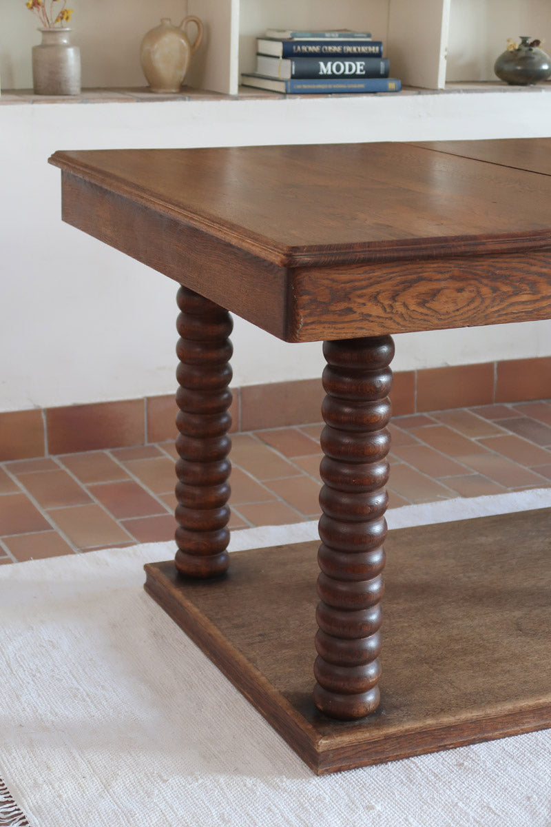Table à manger vintage en chêne massif, pieds tournés à bobines, socle plein, plateau ouvrant central, art déco rustique esprit Charles Dudouyt