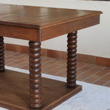 Table à manger vintage en chêne massif, pieds tournés à bobines, socle plein, plateau ouvrant central, art déco rustique esprit Charles Dudouyt